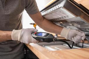 Kitchen Appliances Installer Checking For Gas Leaks Using a Detector photo