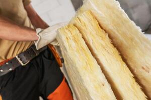 Construction Worker Moving Pieces of Mineral Wool For a House Insulation photo