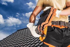 Roofing Worker Moving a Black Roof Ceramic Tiles photo