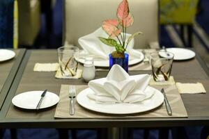 White serviette decorated on dinner set table in restaurant photo