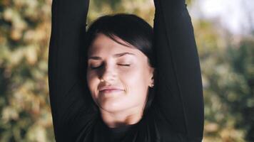 Young woman doing warm-up on terrace. raises his hands up. In reflection. Workout. Exercise. video