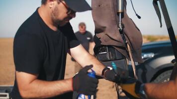 Film crew protecting the movie camera from a sandstorm. Lubrication of camera mount parts video