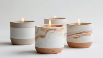 A set of handpoured candles in minimalist clay vessels each with a unique subtle marbling effect. photo