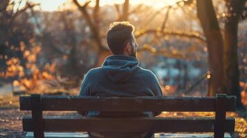 A man sitting on a wooden bench using visualization to visualize himself overcoming his fears and achieving personal growth. photo