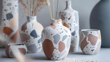 A terracotta vase with a modern twist featuring a terrazzo pattern in shades of grey white and blush pink. photo