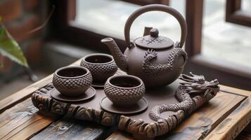 A small intricately designed clay tea set featuring a traditional dragon motif photo