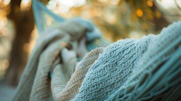 A person lounging in a hammock with a cashmere throw dd over them to protect from the cool breeze photo