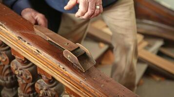 A carpenter uses a hand plane to smooth out a wooden railing meticulously matching the original style for a restored historical home photo