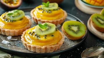 A coconut cream tart filled with layers of tangy mango and passionfruit curd topped with a slice of fresh kiwi photo