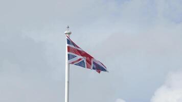 echt Union Jack Flagge von das vereinigt Königreich auf Fahnenstange flattern im das Wind. vereinigt Königreich Flagge winken im Wind von großartig Großbritannien. Vereinigtes Königreich aus EU Brexit. National Flagge von Vereinigtes Königreich Krönung. britisch Flagge video