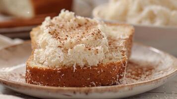 A warm slice of coconut bread topped with a generous smear of creamy coconut butter and a sprinkle of cinnamon photo