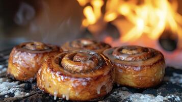 Fragrant cinnamon rolls freshly baked in a woodfired oven are coated in a gooey glaze that melts in your mouth. The smoky notes from the fire enhance the warm comforting flavor photo