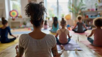 A parent leading a yoga session for parents and children at an alcoholfree health and wellness playdate with mats and herbal tea set up for everyone photo