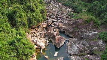 Serenely flowing stream through the rocky terrain of the Annamite Range in Vietnam, showcasing the untouched natural beauty of Southeast Asia video