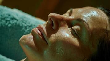 A persons face visibly peaceful and calm as they lay on a massage table and receive the benefits of a deep tissue massage. photo