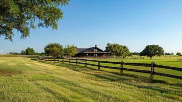 A sprawling ranch house with a wide front porch and a wooden fence enclosing the vast fields and stables photo