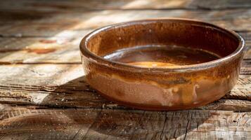 A finished clay baking dish fresh out of the kiln with its glossy glaze glistening in the sunlight and small imperfections adding character to its overall appearance. photo