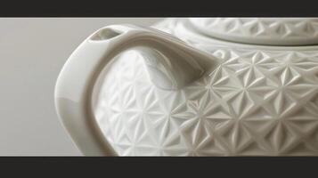 The smooth glossy surface of a porcelain teapot enhanced by a precisely engraved geometric pattern. photo