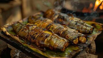 At a small rustic restaurant the food critics are served a traditional dish of fish wrapped in banana leaves and cooked over an open fire. They debate the tenderness of the fish an photo