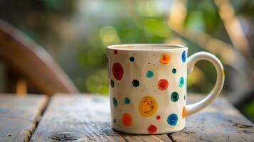 A creative pattern of handpainted polka dots covers the surface of a lively and charming mug perfect for a morning cup of coffee. photo