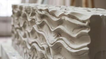 Layers of clay are carefully stacked and creating a visually striking raised effect in the final relief panel. photo