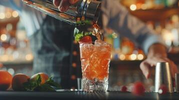 A bartender wearing a bowtie carefully pours a fruity mocktail into a shaker photo