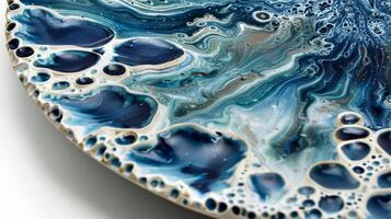 A platter with an intricate and abstract design of dark blue and white speckles created through the layering and vaporization of soda glazes in the firing process. photo