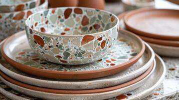 A set of terracotta dinner plates with a unique terrazzo pattern made from a medley of green brown and beige clay. photo