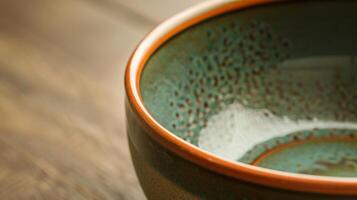 A closeup of a ceramic bowl with a oneofakind glaze showcasing a personalized message on the inside. photo