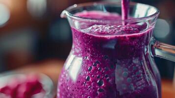 A glass pitcher filled with a vibrant purple smoothie a mix of acai banana and almond butter waiting to be poured and enjoyed photo