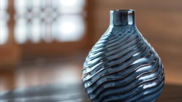 A handcrafted vase featuring a rippled pattern resembling the movement of waves in a glossy charcoal glaze. photo