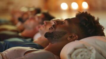 A diverse group of men lying in Savasana corpse pose at the end of a restorative yoga class with their hands resting on their chests and a sense of calm on their faces photo