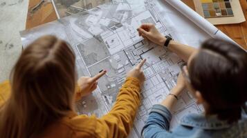 Two people a blueprint pointing and debating the best way to approach a complicated room layout photo