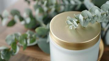 A handpoured soy wax candle in a frosted glass jar topped with a gold lid and emitting a stunning rosewood scent photo