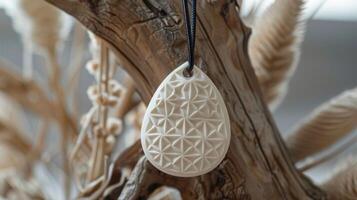 A ceramic pendant with intricate geometric patterns carved into its surface giving it a unique textured look and feel. photo