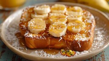 A tropical take on a classic breakfast dish with coconut French toast topped with fresh bananas and passion fruit syrup photo