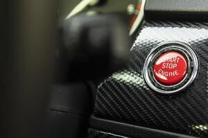 Red engine start button detail. Car dashboard with focus on red engine start stop button photo