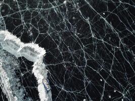 From above, a view of the frozen ice of Lake Baikal. A group of tourists lie ice photo