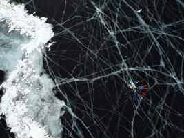 desde arriba, un ver de el congelado hielo de lago baikal grupo de turistas mentira hielo foto