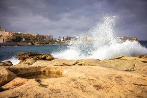 A lot of spray from the waves of the ocean Coast of the island of Malta winter photo