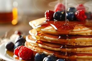 Stack of pancakes with berries and syrup, close up with steam rising photo