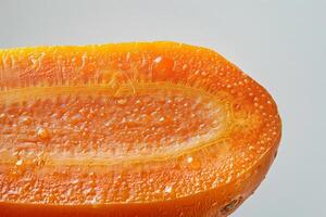 Carrot cut in half lengthwise, showcasing its crisp texture and vivid orange hue against a light background photo