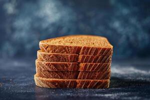 Rye bread slices on a deep blue to black gradient background, highlighting the dense texture and rich color photo