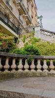 Elegant stone balustrade with lush greenery in an urban garden, ideal for architecture and landscape design content, especially in spring and Earth Day themes photo