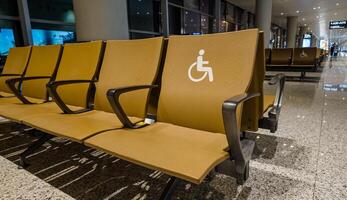 accesible asientos en un moderno aeropuerto esperando zona designado con un invalidez símbolo, exhibiendo inclusividad y conformidad con ada normas relacionado conceptos, accesibilidad, viajar, ada conciencia foto