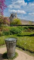 Springtime in Paris with a focus on a trash bin in the Tuileries Garden, showcasing environmental cleanliness and tourism, ideal for Earth Day promotions photo
