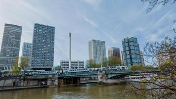 Urban skyline with modern high rise buildings and a train crossing a bridge over a river, showcasing city transportation and architecture photo