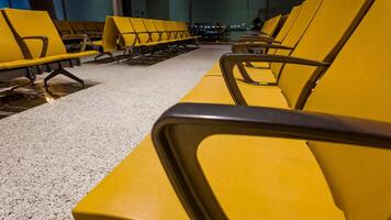 Empty yellow seating at an airport terminal at night, depicting the concept of travel, business trips, and holiday seasons like Christmas and Thanksgiving photo