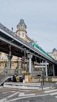 Parisian metro train crossing an iron bridge near Trocadero on a cloudy day in Paris, France, architecture and urban transportation, April 14th, 2024 photo