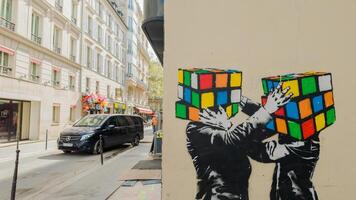 urbano Arte en París, Francia, presentando dos rubiks cubitos en un pintada estilizado imagen, simbolizando problema resolviendo y creatividad, capturado abril 14, 2024 foto